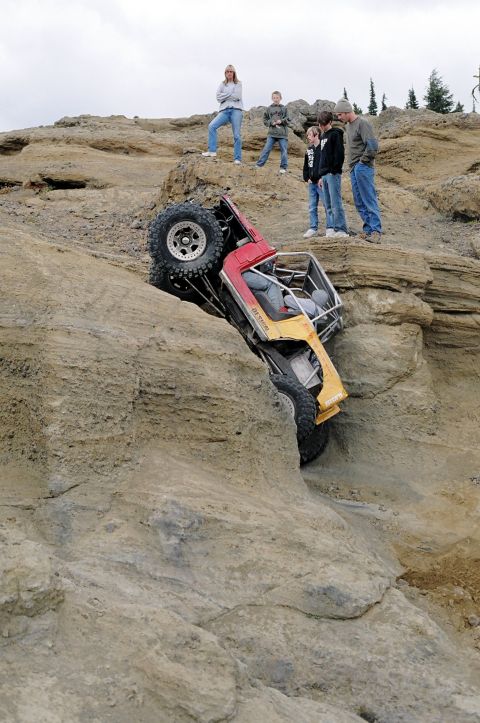 1979 Ford Bronco - Spectators watch as an off-road vehicle navigates a steep, rocky incline.