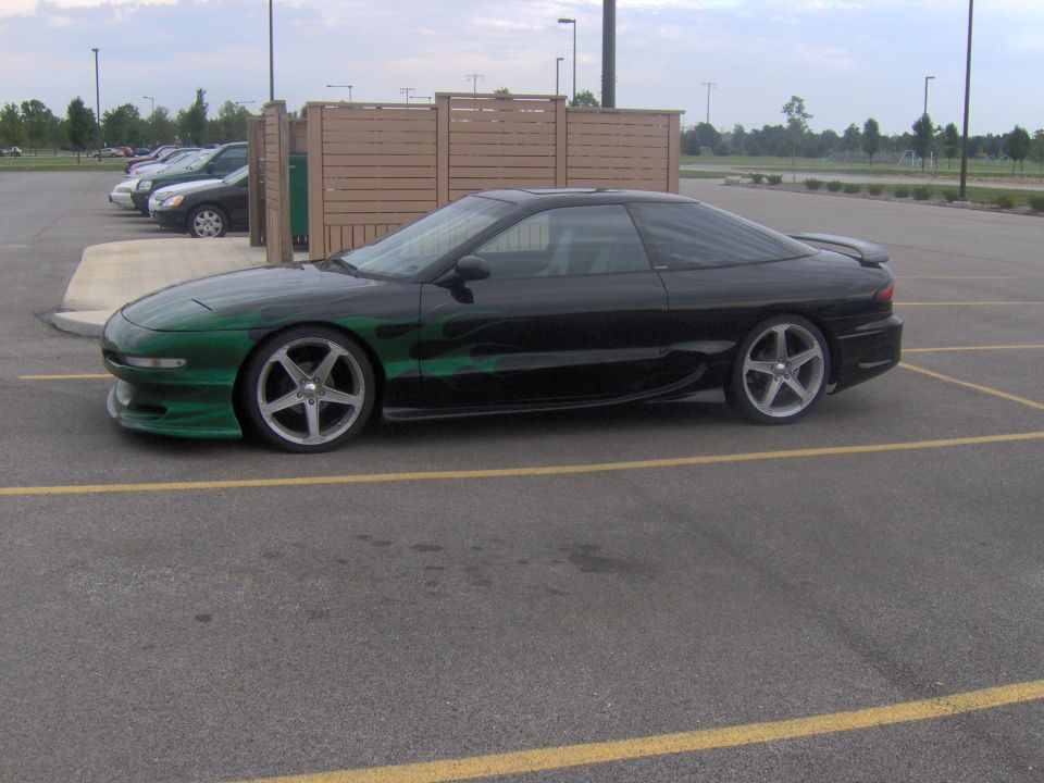 1994 Ford Probe with green flame graphics parked in a lot