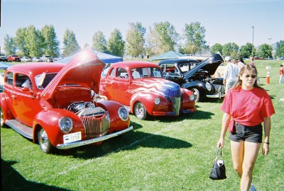 1972 Ford Ranchero - Three classic sedans are displayed on a grassy field at an outdoor event.