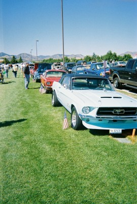 1972 Ford Ranchero - A white 1967 convertible with a black top and distinctive blue lower body trim is parked on a grassy field alongside other vehicles.