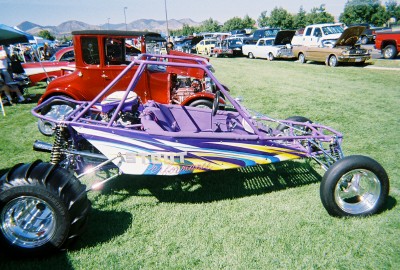 1972 Ford Ranchero - A custom purple dune buggy with colorful graphics is displayed at an outdoor car show.