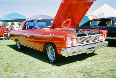 1972 Ford Ranchero - A bright red coupe, possibly a 1966 model, is displayed with its hood raised at an outdoor event.