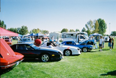 1972 Ford Ranchero - Cars are displayed on a grassy field under a clear blue sky, with tents and spectators present at a car show.