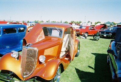 1972 Ford Ranchero - A custom orange coupe is displayed with its hood and door open at an outdoor car show.
