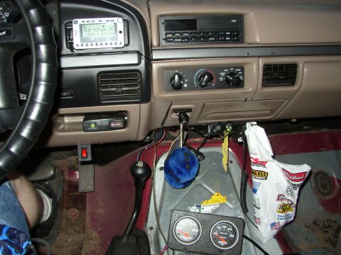 1995 Ford Bronco - The interior of a truck shows aftermarket gauges, a fuzzy blue air freshener, and a digital display on the dashboard.