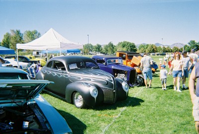 1972 Ford Ranchero - Several custom hot rods and a truck are displayed on a grassy field under a clear sky.