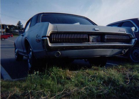 1968 Mercury Cougar - The rear of a 1968 Mercury Cougar is visible, parked next to another vehicle.