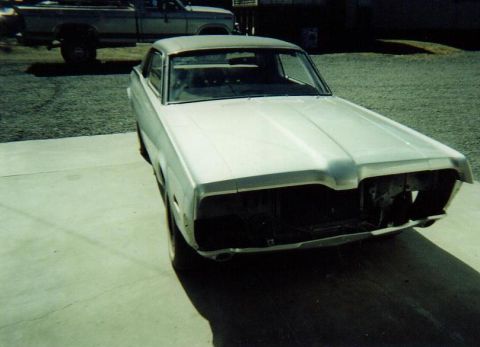 1968 Mercury Cougar - A silver coupe, likely a 1967 model, sits unfinished with its front end disassembled, while a pickup truck is parked nearby.