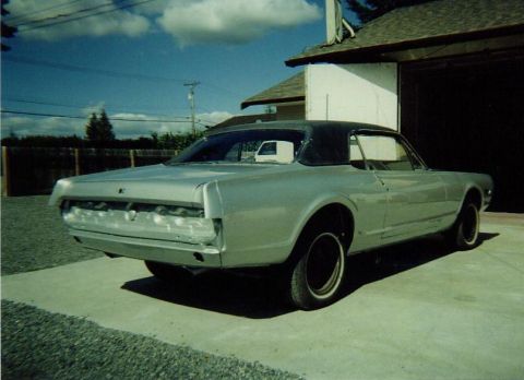 1968 Mercury Cougar - Rear view of a 1968 Mercury Cougar coupe undergoing restoration, parked outside a garage.
