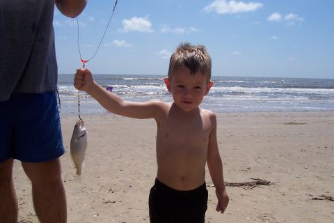 1987 Ford Bronco - A young boy proudly displays his catch of the day while on a beach trip.