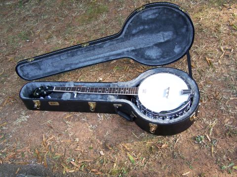 1979 Ford F-150 - Banjo with its case open, placed on the ground outdoors.