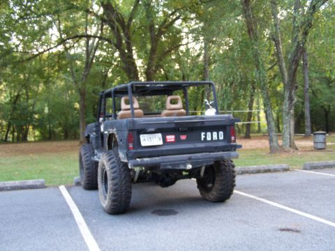 1979 Ford F-150 - Rear view of a modified black Ford Bronco with a roll cage and off-road tires.