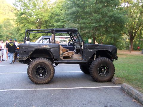1979 Ford F-150 - Modified black SUV with a roll cage and oversized tires parked in a lot, with another vehicle visible behind it.