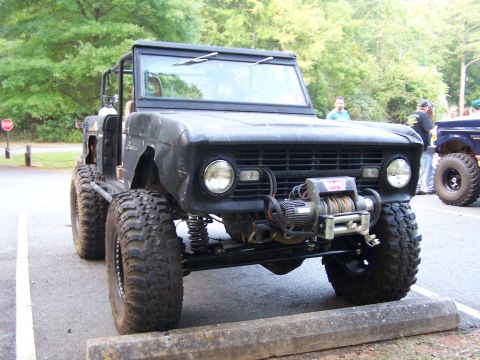 1979 Ford F-150 - Modified black off-road SUV, likely a 1970s Ford Bronco, equipped with a winch and oversized tires, parked outdoors.