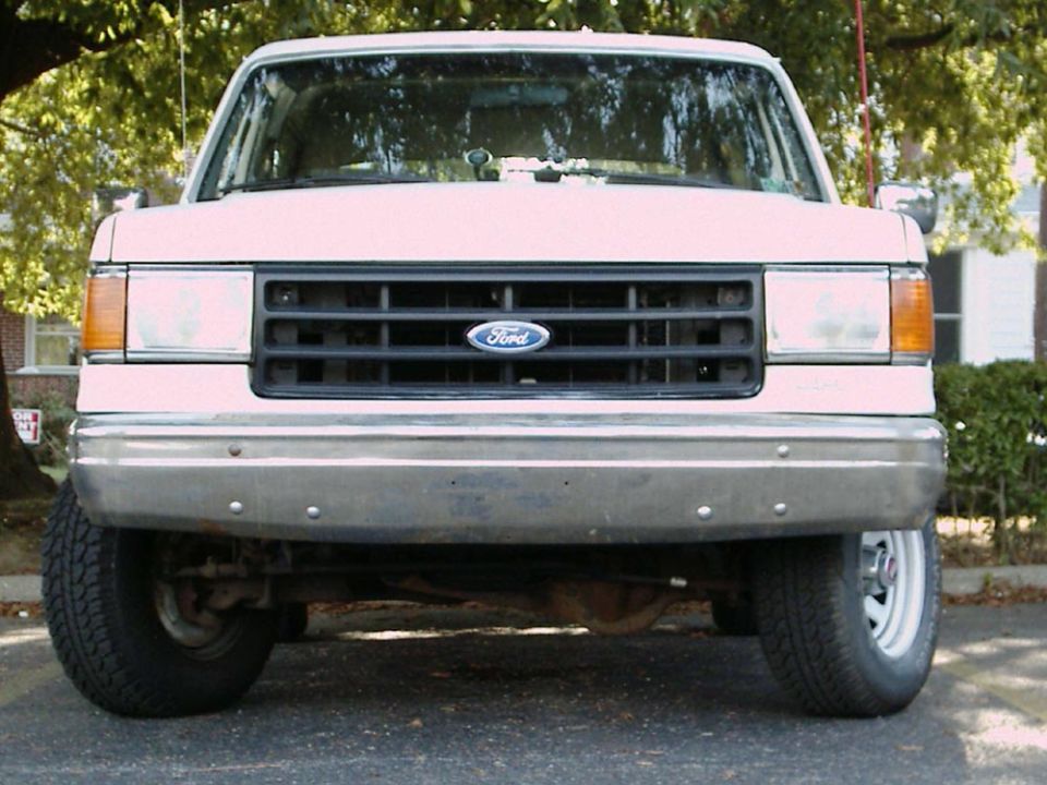 Front view of a pink Ford F-Series truck, likely from the late 1980s