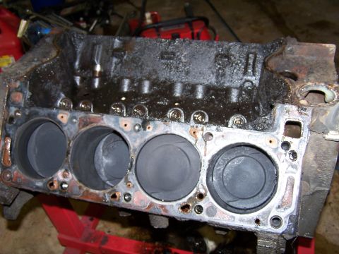 1979 Ford F-150 - A heavily soiled engine block is shown with its cylinders exposed, indicating significant wear and tear.