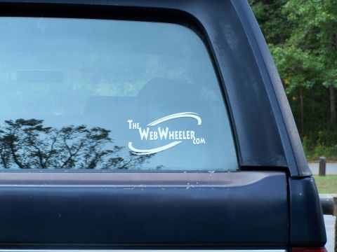 1979 Ford F-150 - A sticker on the rear window of a dark vehicle displays TheWebWheeler.com.