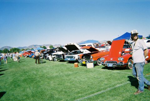 1972 Ford Ranchero - A car show features a variety of vintage vehicles lined up on a sunny day with mountains in the background.