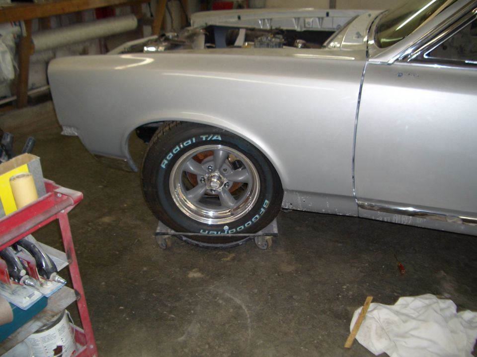 Silver 1967 Pontiac GTO side view in garage on wheel dolly, BFGoodrich Radial T/A tire on chrome wheel