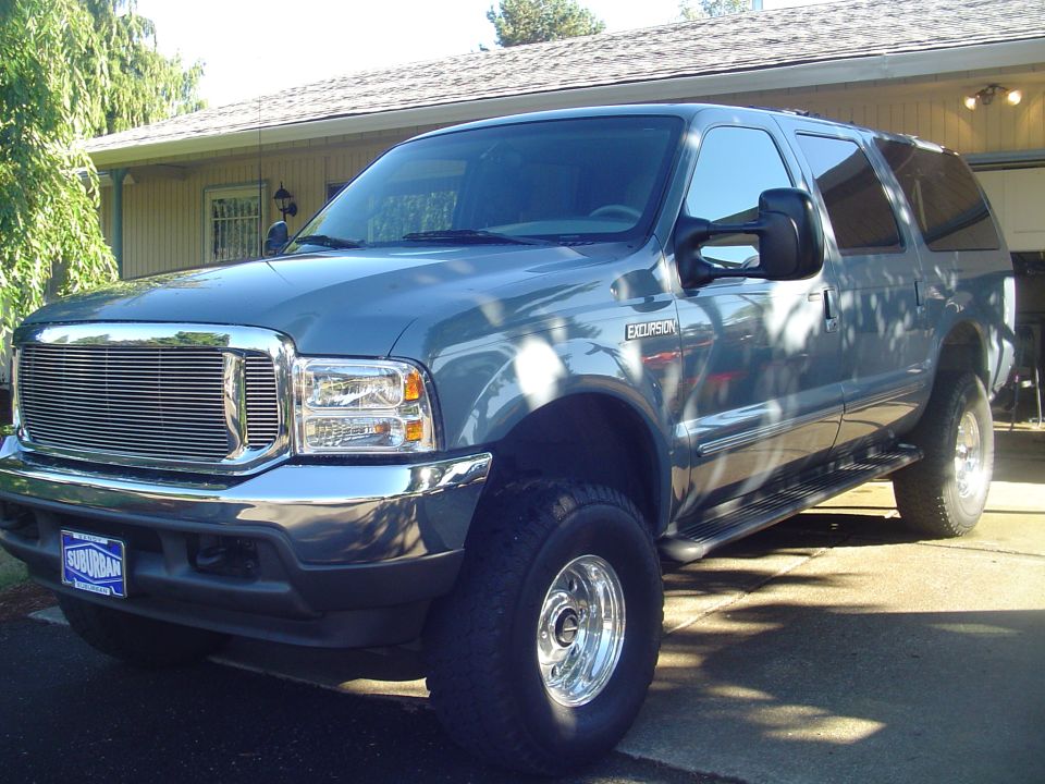 Gray 2000 Ford Excursion SUV parked in driveway, front quarter view