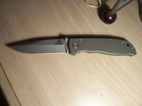 1995 Ford Bronco - A Gerber folding knife is shown on a wooden table.