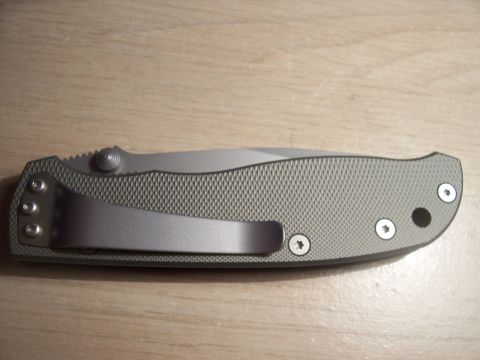 1995 Ford Bronco - A gray folding knife with a textured handle and a silver pocket clip is shown on a wooden surface.