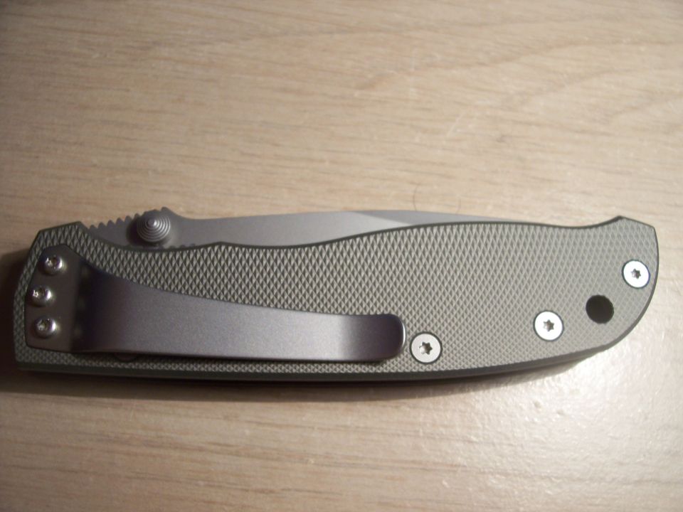 Gray folding knife with textured handle and silver pocket clip