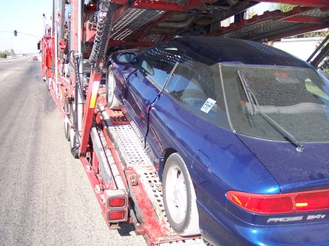 1995 Ford Probe - A blue 1995 Ford Probe is loaded onto a car carrier.