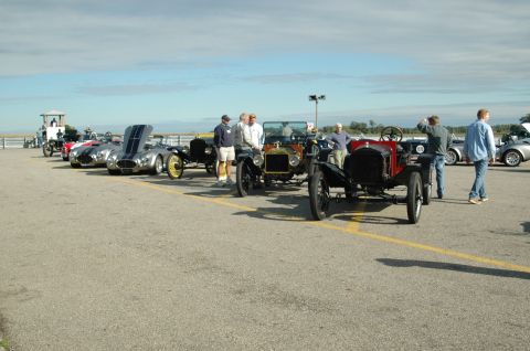 2000 Ford Mustang - A collection of classic cars are displayed outdoors on a sunny day.