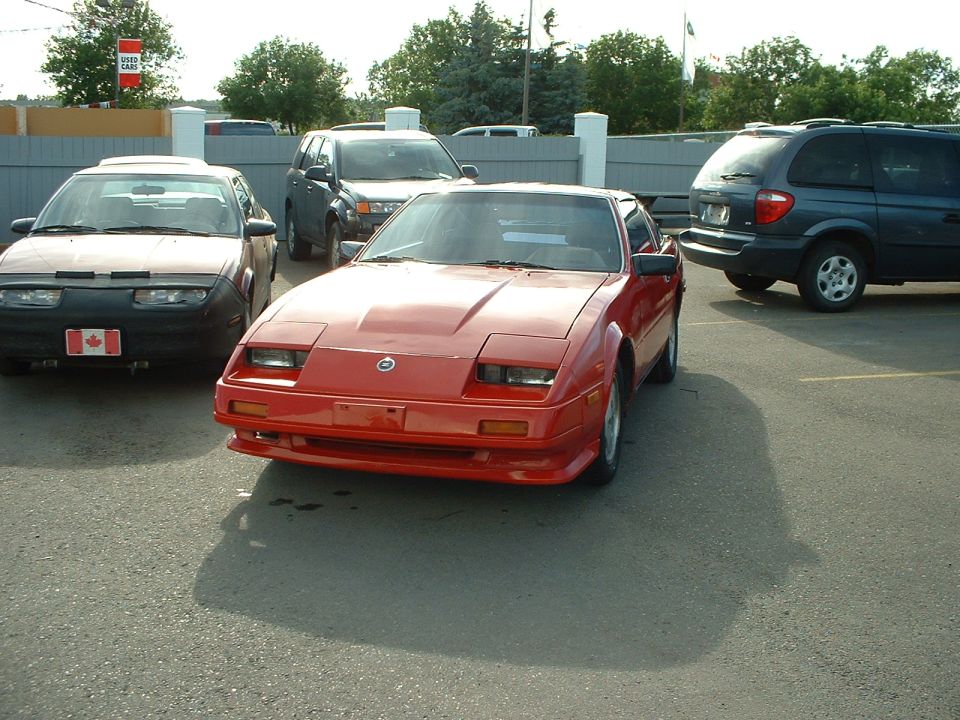Red Nissan 300ZX coupe parked front-3/4 in a used-car lot