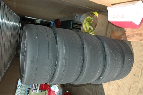 2000 Ford Mustang - A stack of four used racing tires is stored in a trailer or garage.