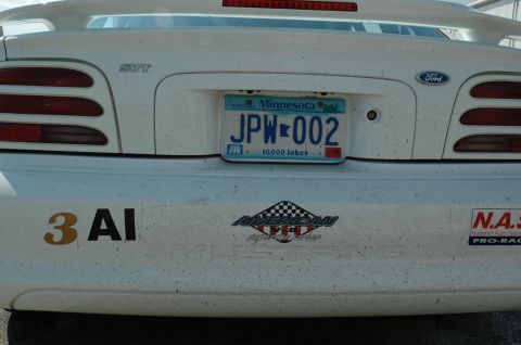 2000 Ford Mustang - The rear of a white Ford Mustang SVT shows a Minnesota license plate and various racing decals.