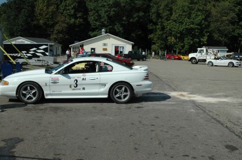 2000 Ford Mustang - A white 1994 Ford Mustang coupe, marked with racing decals and the number 3, is parked at a track event.