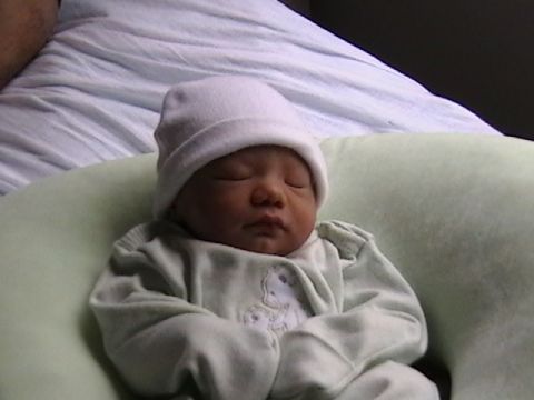 1997 Ford Probe - A baby sleeps peacefully in a soft green pillow, wearing a white hat and a light green outfit.
