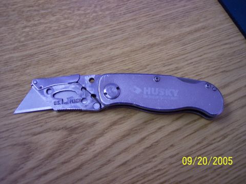 1987 Ford Bronco - A silver Husky folding utility knife is shown with its blade extended, displaying patent pending information and the brand name.