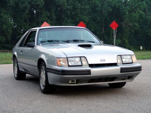 1986 Ford Mustang - This silver 1986 Ford Mustang hatchback is captured from a front three-quarter perspective.
