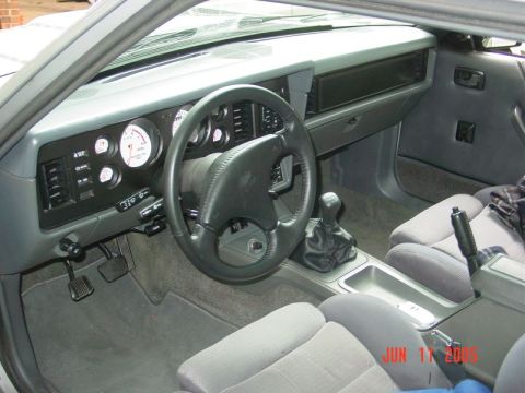 1986 Ford Mustang - Interior view of a 1986 Ford Mustang, the dashboard, steering wheel, and seats.