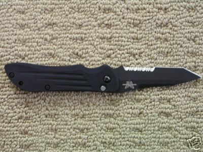 1988 Ford Bronco - Black folding knife with serrated edge is shown on a carpeted surface.