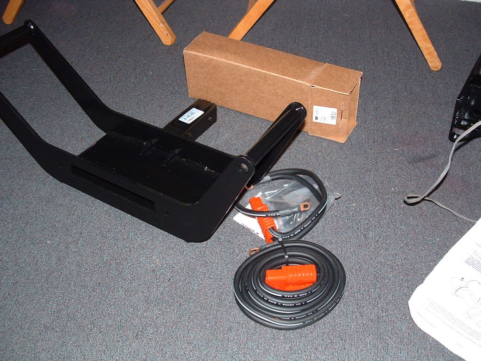 Winch mount, coiled cables with orange connectors, and a cardboard box on carpet