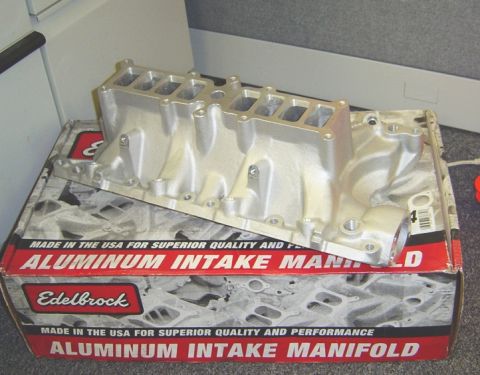 1986 Ford Bronco - An aluminum intake manifold sits on its original packaging, which details its origin and manufacturer.