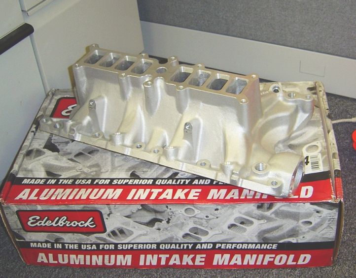 Bare aluminum V8 intake manifold resting on its Edelbrock box