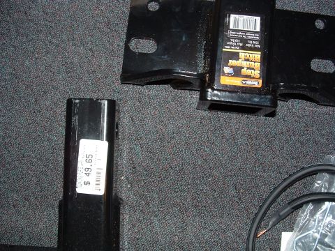 1993 Ford Bronco - A hitch receiver and another metal part are shown, with a price tag visible on one piece.