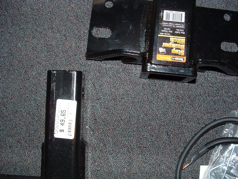 Hitch receiver with 'Step Bumper Hitch' label and price tag on another part