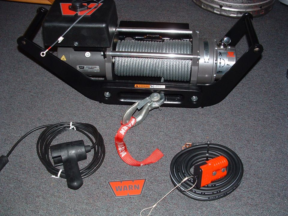 Warn winch with hook, remote, and cables on carpet