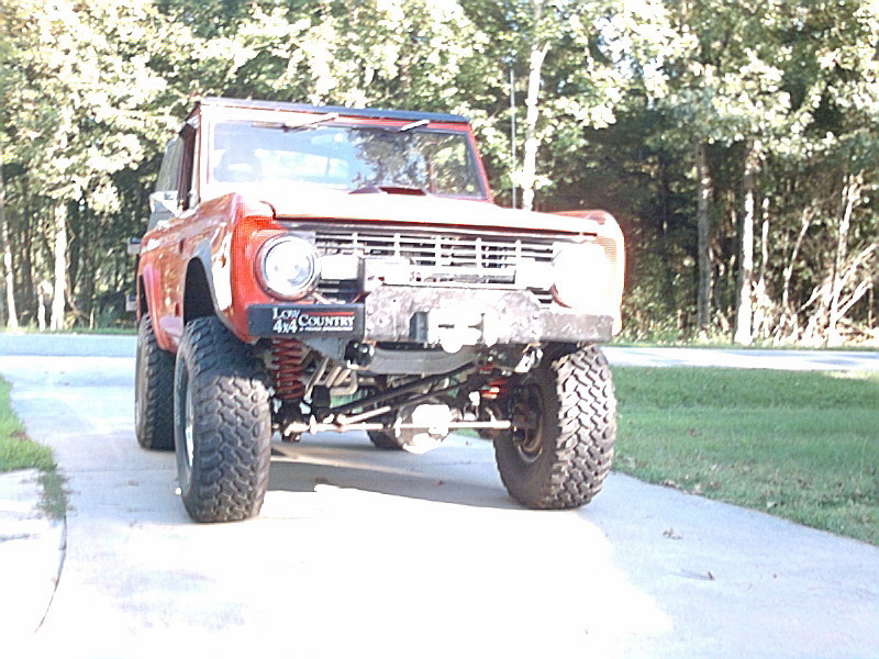 Lifted red SUV with off-road tires and a winch on the front bumper. It has a 'Low Country 4x4' sticker on the fender
