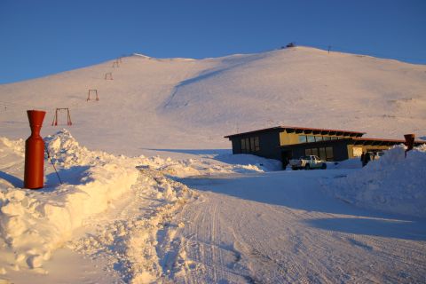 2003 Jeep TJ - A building at a ski resort is surrounded by snow, with ski lift towers visible on the mountain.
