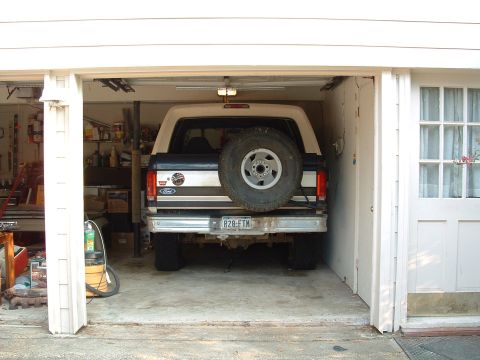 1993 Ford Bronco - This 1993 Ford Bronco is parked in a garage, showing its rear end with a spare tire mounted on the tailgate.