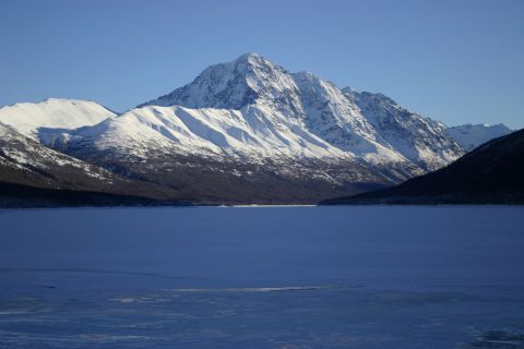 2003 Jeep TJ - A vast, frozen lake stretches out before snow-covered mountains on a clear day.