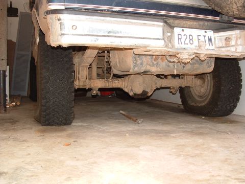 1993 Ford Bronco - The underside of a truck is shown, focusing on the rear axle, suspension, and tires.