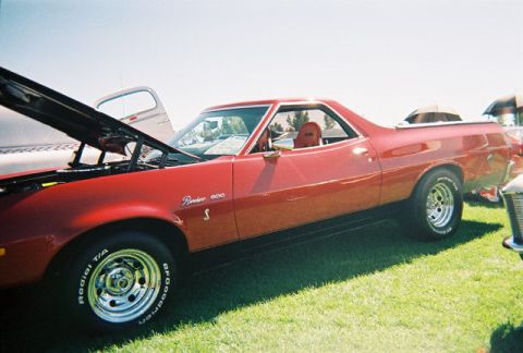 1972 Ford Ranchero - This red 1972 Ford Ranchero has its hood open, revealing a red interior and chrome wheels.